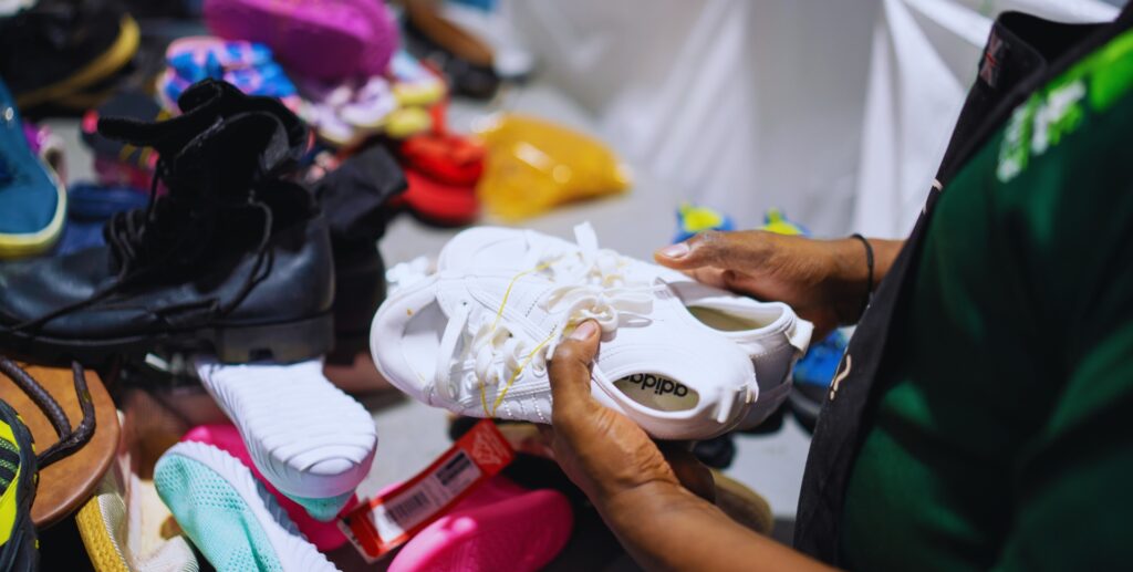 Branded white Adidas used shoes on sorting table at MS Group facility
