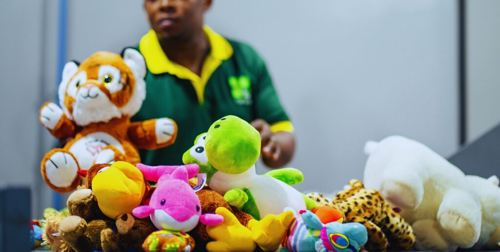 Colorful soft toys being sorted by MS Group staff in branded uniform
