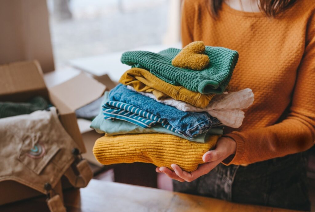 European woman lovingly preparing clothes for donation