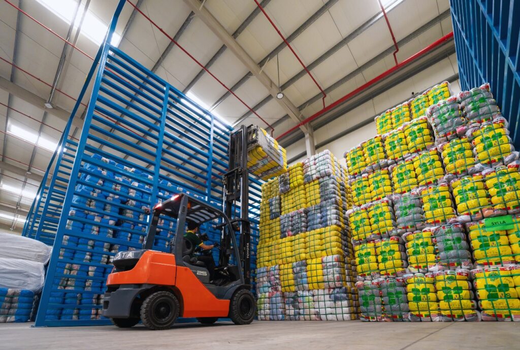 Forklift placing second hand clothing bales into warehouse racking