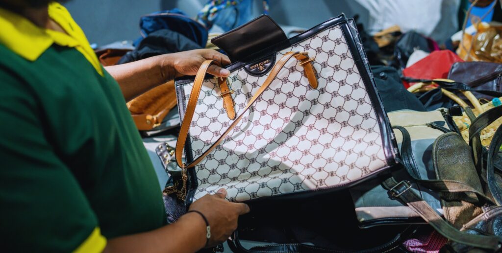 Sorting professional showing a white second hand bag with leather strap at MS Group